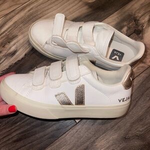 Veja Velcro Sneakers. Has gold details on the side and back.
